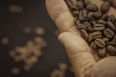 Close-up of hand holding coffee beans