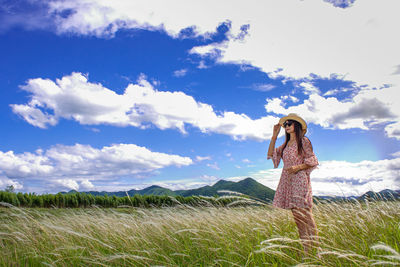 Woman standing on field against sky