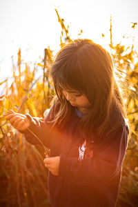 Rear view of woman with arms raised on field