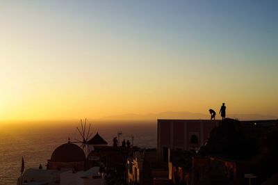 High angle view of buildings against sea during sunset