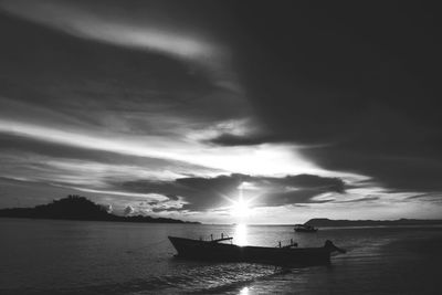 Silhouette boat in sea against sky