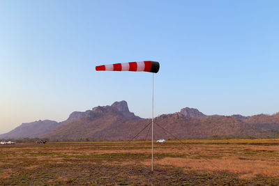 Red flag on field against clear sky