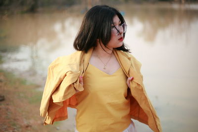 Young woman standing against a water