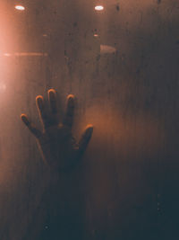 Shadow of person hand on glass window