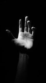 Close-up of human hand against black background