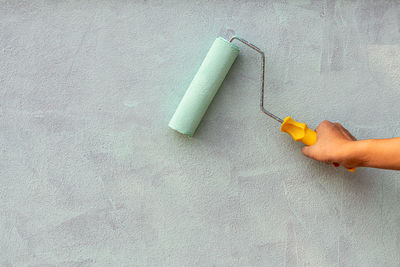 High angle view of hand holding paper against wall