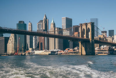 City at waterfront against blue sky