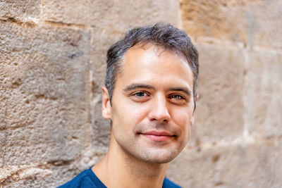 Portrait of smiling young man against wall