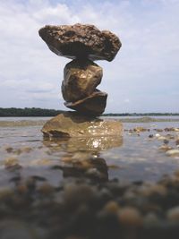 Stack of pebbles on beach against sky