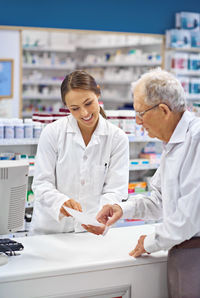 Man pointing at prescription held by pharmacist