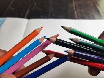 High angle view of colored pencils on paper