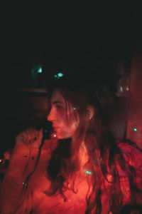 Portrait of young woman smoking at night