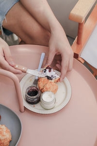 High angle view of hand holding cake on table