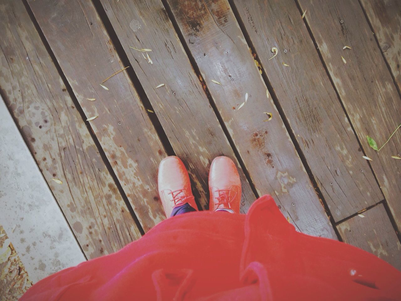 low section, person, shoe, high angle view, personal perspective, human foot, footwear, wood - material, standing, red, part of, boardwalk, wooden, relaxation, flooring, day, lifestyles