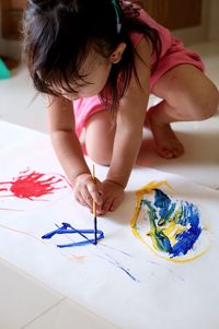 High angle view of girl painting on floor 