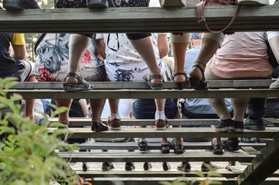 Low section of people sitting on bench at stadium