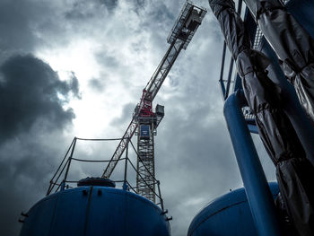 Low angle view of crane against sky