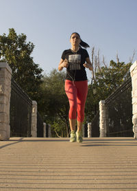 Low angle view of young woman against clear sky