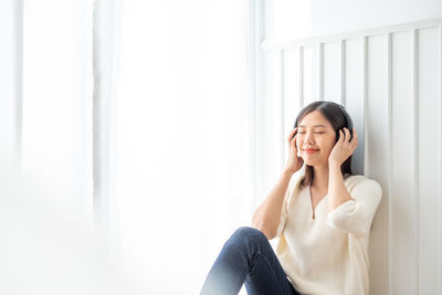 Smiling young woman sitting at home