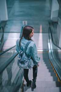 Woman looking at camera while standing on railing