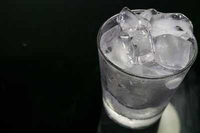 Close-up of beer glass against black background