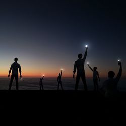 Silhouette of girl playing at sunset