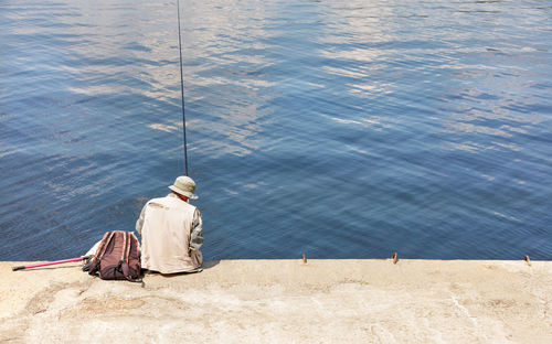 High angle view of men fishing at lake