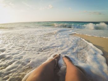Low section of man relaxing on beach
