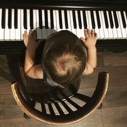 Directly above shot of boy playing piano at home