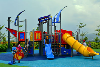 Low angle view of men playing at playground against sky