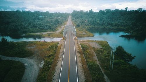 Panoramic view of road by trees against sky