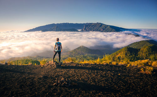 Man standing on mountain against sky