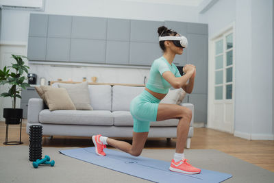 Side view of young woman exercising in gym