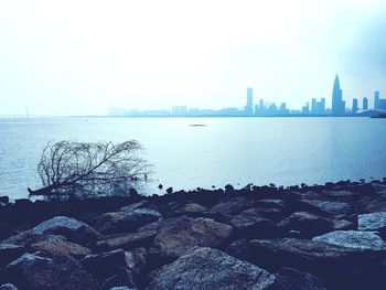 Scenic view of sea by city against sky