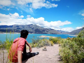 Rear view of man looking at lake