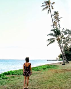 Rear view of woman standing on beach