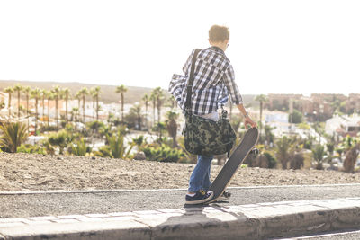 Rear view of man standing against clear sky