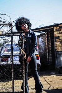 Full length of young man standing against built structure