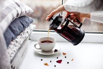 Midsection of woman pouring coffee in cup