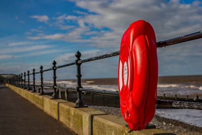 Red flag on beach against sky