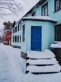 Houses in snow against sky during winter
