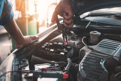 Midsection of man repairing car