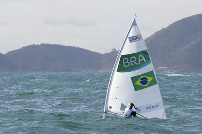 Rear view of female athlete windsurfing on sea