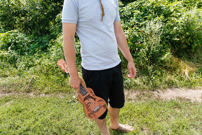 Rear view of man standing on grassy field