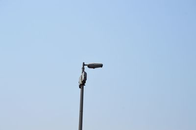 Low angle view of security camera against clear sky