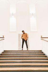 Full length of woman standing on staircase