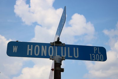 Close-up of road sign against sky