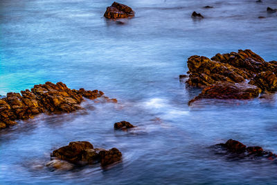 Rock formation in sea against sky