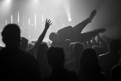 Group of people carrying man at music concert