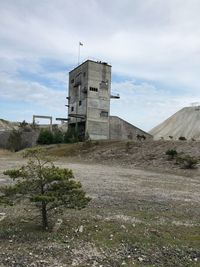 Abandoned building on field against sky